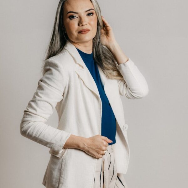 a woman in a white blazer is posing for a picture