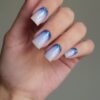 Woman's hand with blue and white ombre nails