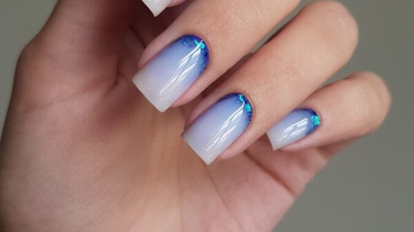 Woman's hand with blue and white ombre nails