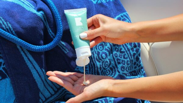 person holding white plastic tube bottle
