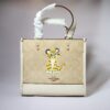 A coach tote bag with a tiger design.