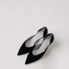 a pair of black shoes sitting on top of a white surface