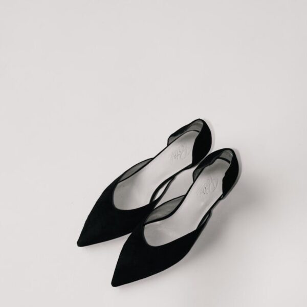 a pair of black shoes sitting on top of a white surface