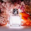 a bottle of perfume sitting next to a bunch of flowers