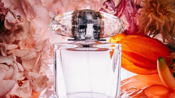 a bottle of perfume sitting next to a bunch of flowers