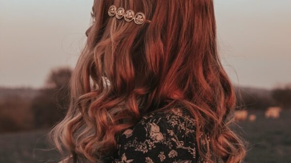 a woman with red hair standing in a field