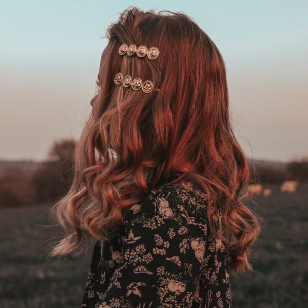 a woman with red hair standing in a field