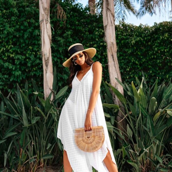 woman in white sleeveless dress wearing brown straw hat standing near green trees during daytime