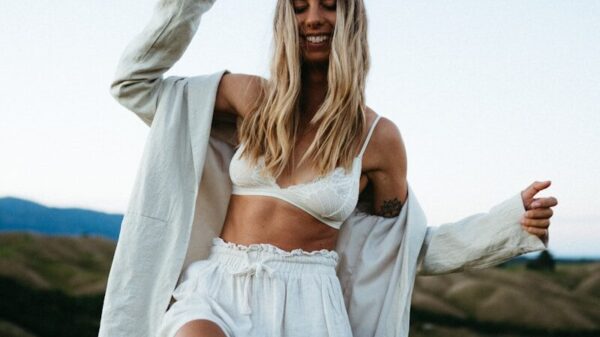 a woman in a white top and shorts posing for a picture