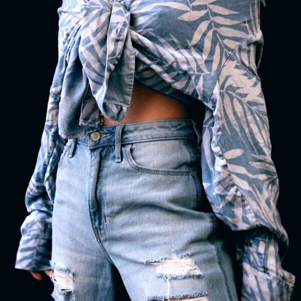 woman in gray and black floral long sleeve shirt and blue denim jeans