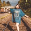 woman in blue long sleeve dress standing on train rail during daytime