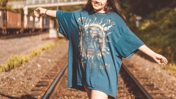 woman in blue long sleeve dress standing on train rail during daytime