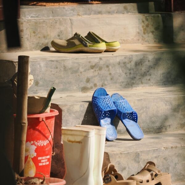 Various shoes and boots on outdoor steps.