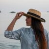 woman in white and blue striped long sleeve shirt wearing brown hat