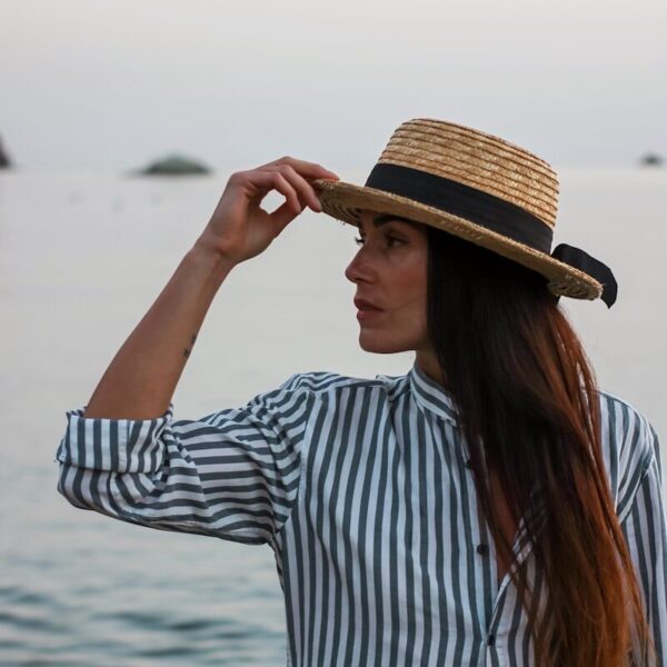 woman in white and blue striped long sleeve shirt wearing brown hat