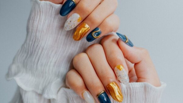 Woman's hands with ornate navy, gold, and white nails