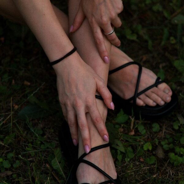 a woman sitting on the ground with her hands on her feet