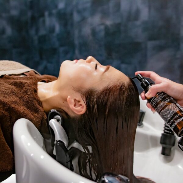 a woman getting her hair washed in a sink