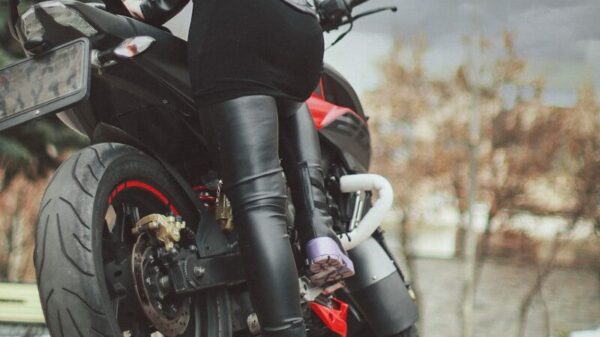 a man in black leather jacket sitting on a motorcycle