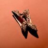 a pair of leopard print shoes on a pink background