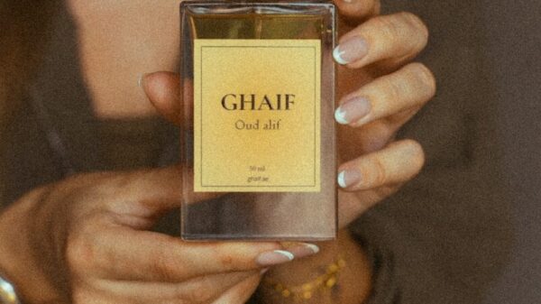Hands holding ghaif oud alif perfume bottle