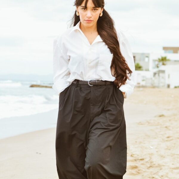 A woman standing on a beach next to the ocean