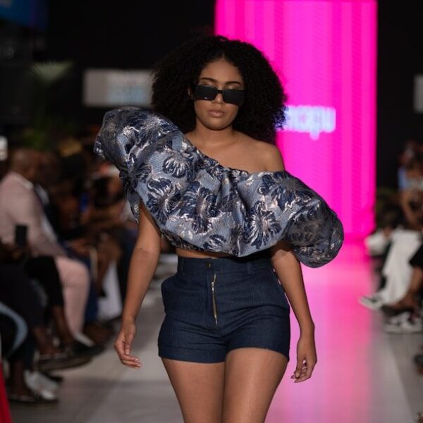 A model struts the runway wearing stylish clothing.