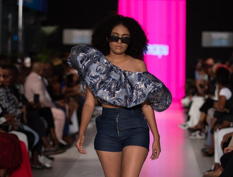A model struts the runway wearing stylish clothing.