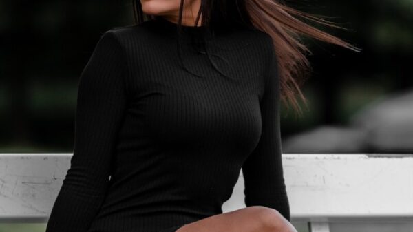 woman in black long sleeve shirt sitting on white wooden bench during daytime