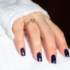 a woman's hand with a blue and white manicure