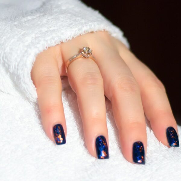 a woman's hand with a blue and white manicure