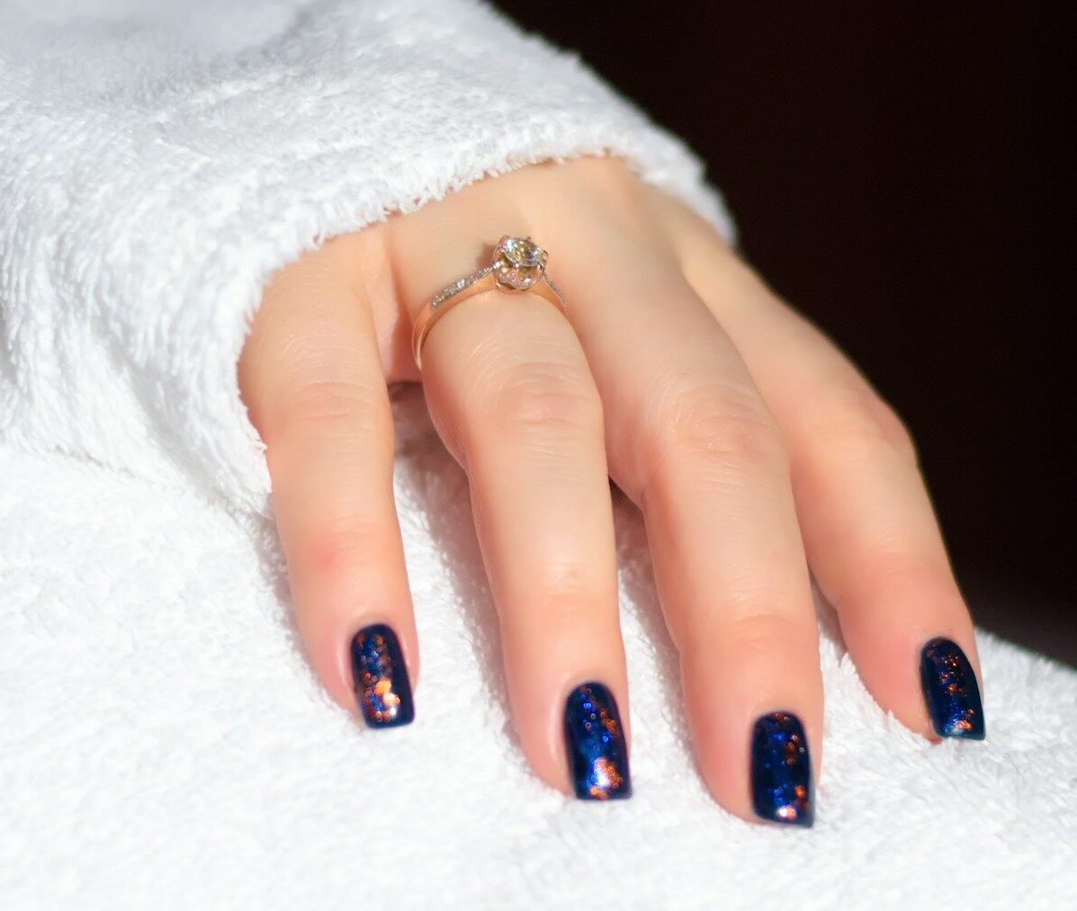 a woman's hand with a blue and white manicure