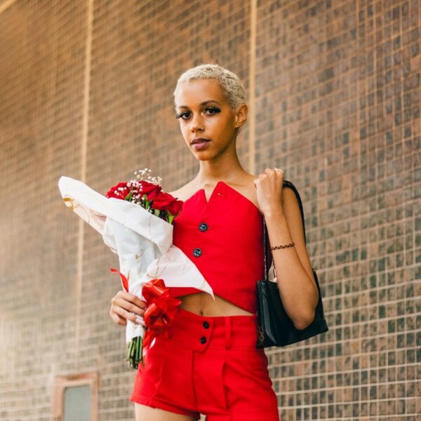 a woman in a red outfit holding a bouquet of flowers