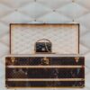 a louis vuitton trunk with a handbag on top of it