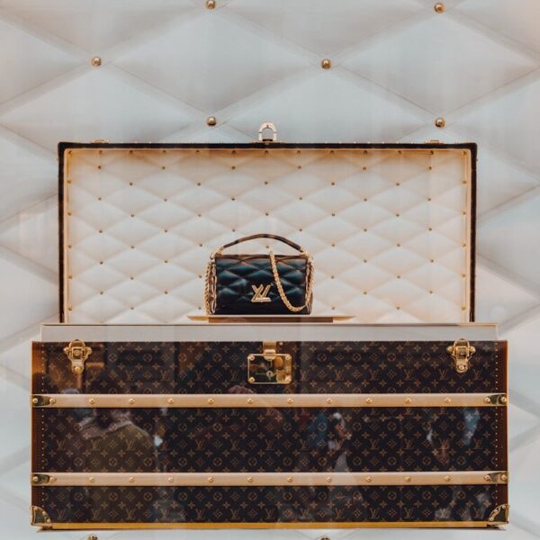 a louis vuitton trunk with a handbag on top of it