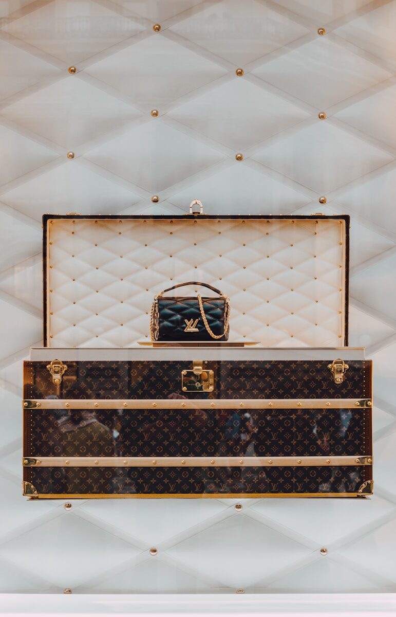 a louis vuitton trunk with a handbag on top of it