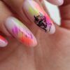 Nails with abstract neon paint and classical bust art.