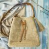 a straw bag sitting on top of a bed