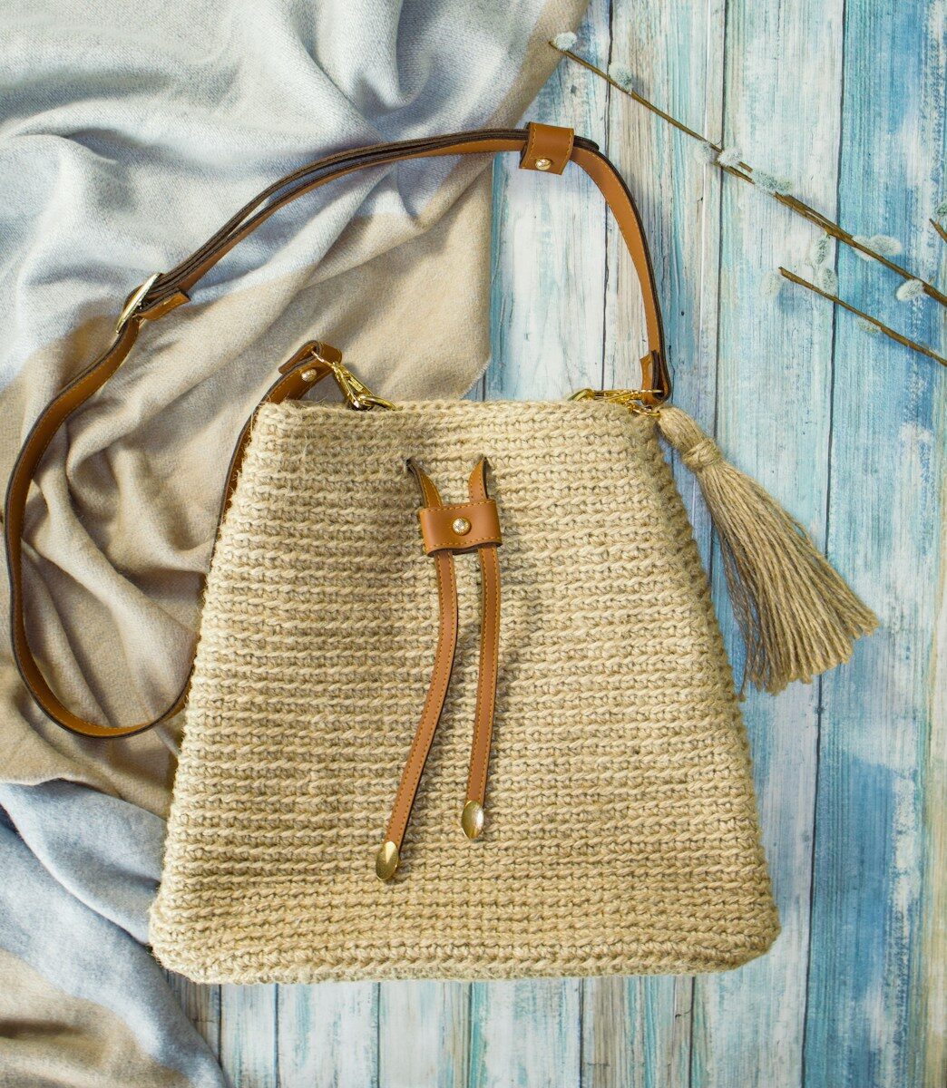a straw bag sitting on top of a bed