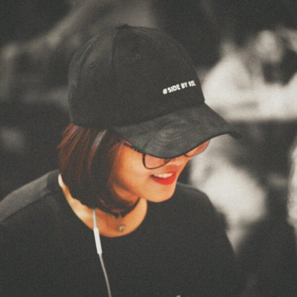 selective color photography of woman wearing black fitted cap