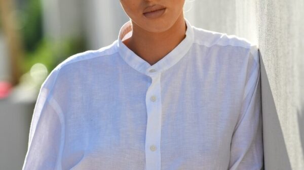 Woman in white shirt leaning against wall