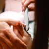 Close-up of a professional manicure session with a nail file used by a beautician.