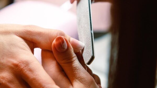 Close-up of a professional manicure session with a nail file used by a beautician.