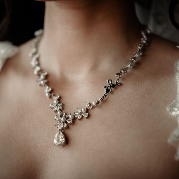 Close-up of a woman wearing a floral design wedding necklace, exuding elegance.